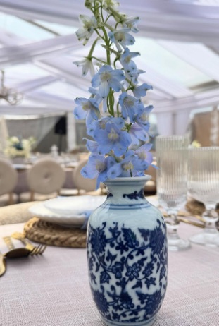 Blue delphinium vase on styled table